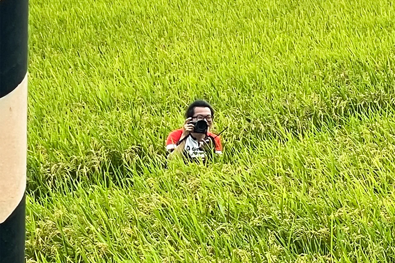 田んぼの中から写真を撮ってくれる張さん